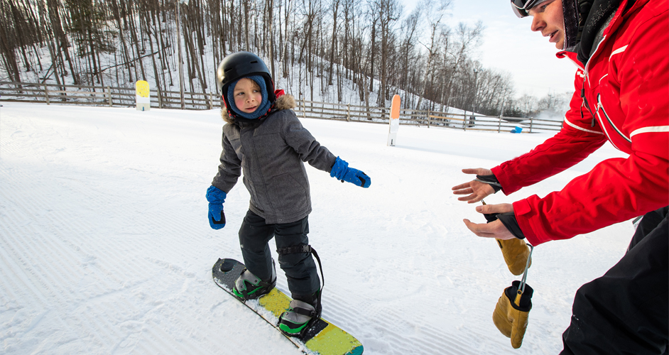 Image of a young boy learning to snowboard.