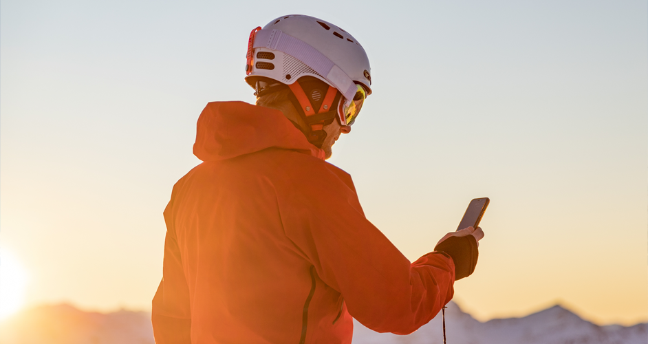 Image of a man on his phone whilst skiing.