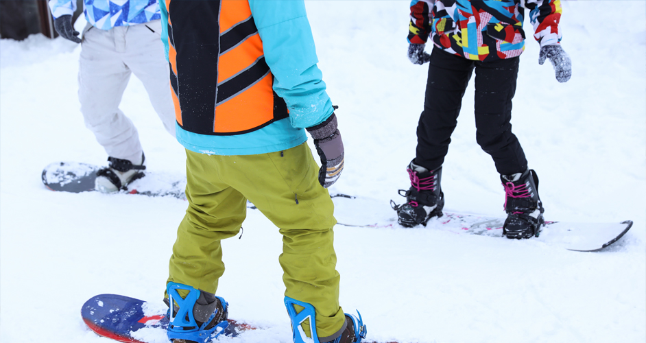 Image of 3 people learning to snowboard.